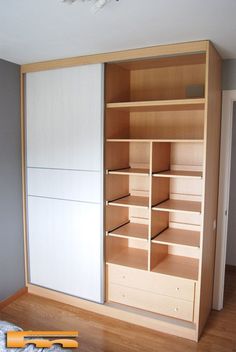 an empty closet with wooden shelves and drawers