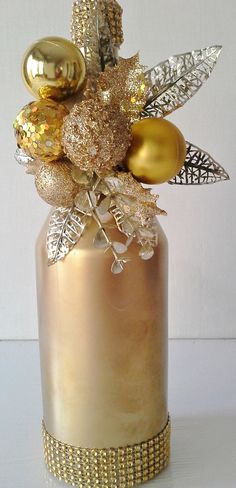 a gold vase with some ornaments in it