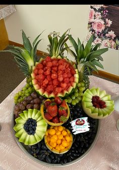 a platter filled with lots of fruit on top of a table