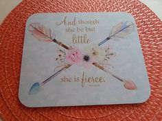 there is a coaster with an image of arrows and flowers on the front, which reads and though she be but little she is fierce