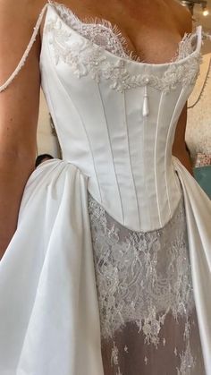 a woman wearing a white wedding dress with lace on it