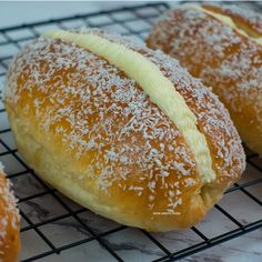 three pastries sitting on top of a cooling rack covered in powdered sugar and sprinkled with icing