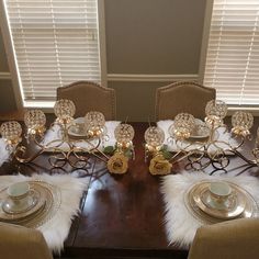 a dining room table is set with place settings for six people and has white fur on the chairs