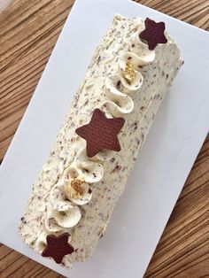 a piece of cake with white frosting and brown stars on it sitting on a plate