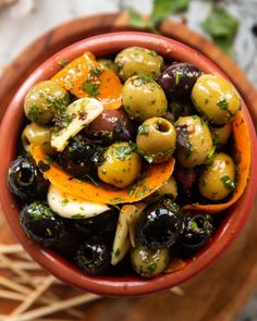 a bowl filled with olives and orange slices