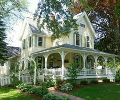 a large white house sitting on top of a lush green field