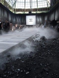 people are standing around in an indoor area with steam coming from the ground