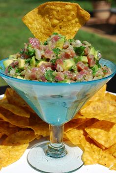 a blue glass bowl filled with salsa and tortilla chips on top of a white plate