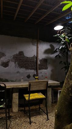 a table with two chairs and a bench in front of a wall that has peeling paint on it