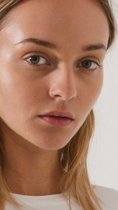 a close up of a woman with long blonde hair and blue eyes looking at the camera