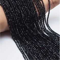 black seed beads are being held by someone's hand