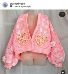 a pink knitted sweater with hearts on it