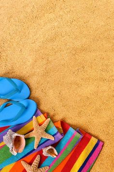 colorful towels, flip flops and starfish on the beach