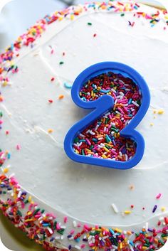 two photos of a birthday cake with sprinkles and the number 2 on it