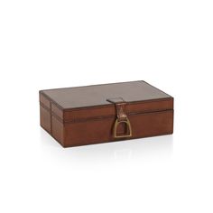 a brown leather box sitting on top of a white surface with an open lid and handle