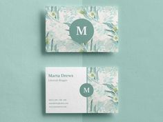 two business cards with the letter m on them, one in green and white flowers