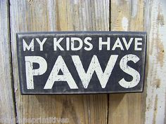 a sign that says, my kids have paws on the side of a wooden fence