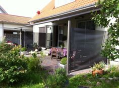 an outdoor patio with tables and chairs surrounded by greenery