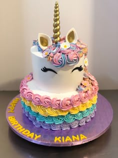 a birthday cake with a unicorn face and rainbow icing