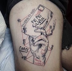 a man with a tattoo on his thigh holding a book