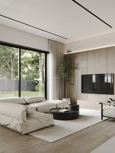 a modern living room with large windows and a flat screen tv mounted on the wall