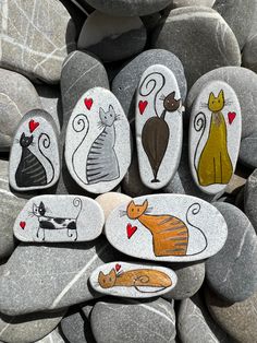 painted rocks with cats and hearts on them are arranged in the shape of a circle