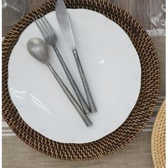 a white plate topped with two silverware on top of a wooden table