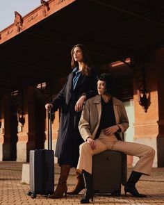 two people standing next to each other with luggage