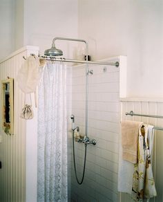 a bathroom with a shower, towel rack and toilet paper roll hanging on the wall