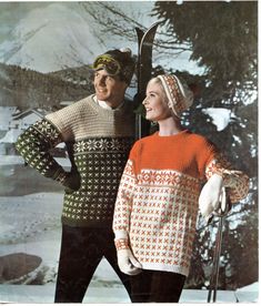 two people standing next to each other wearing skis and sweaters in the snow