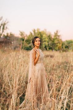 a woman standing in tall grass wearing a dress