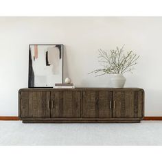 a large wooden cabinet sitting on top of a white carpeted floor next to a plant