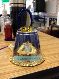 a glass bell with a gold crown on it sitting on top of a wooden table