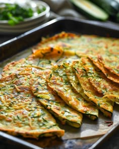 a pan filled with cooked zucchini on top of a table