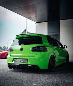 a green car parked in front of a building