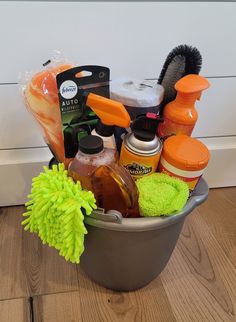 a bucket filled with cleaning supplies on top of a wooden floor