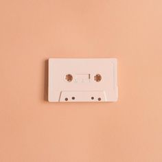 an old fashioned white cassette player on a pink wall