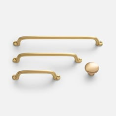 two brass handles and a ball on a white background