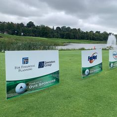 four signs on the grass with water in the background at fox financial planning group's golf tournament