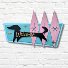 a sign that says welcome with a dachshund in the center and stars around it