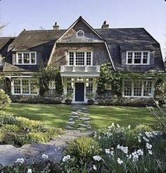 a large house with lots of windows in the front yard and landscaping on both sides