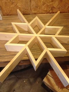 a wooden snowflake sitting on top of a table next to wood planks