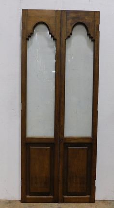 an old wooden double door with glass panels