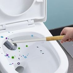 a person cleaning a toilet with a brush