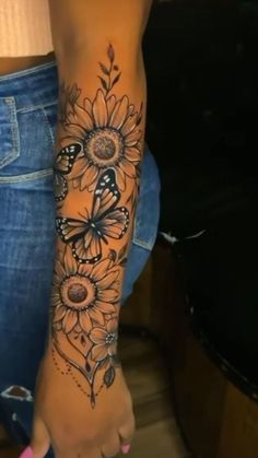 a woman's foot with sunflowers and butterflies tattooed on the side of her leg