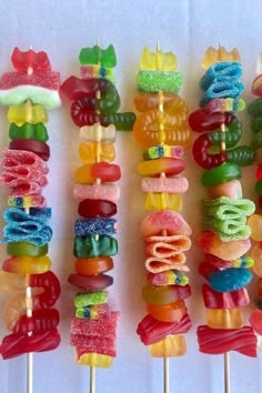 there are many colorful candy lollipops on the skewers with candles