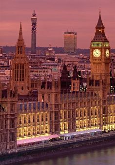 the big ben clock tower towering over the city of london at dusk, as seen from across the river thames