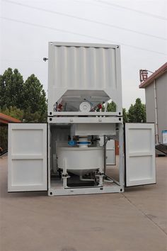 a large white container sitting in the middle of a parking lot with its doors open