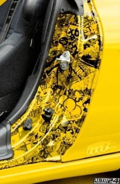 the interior of a yellow sports car with black and white designs on it's doors