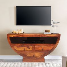 a flat screen tv mounted to the side of a wooden cabinet